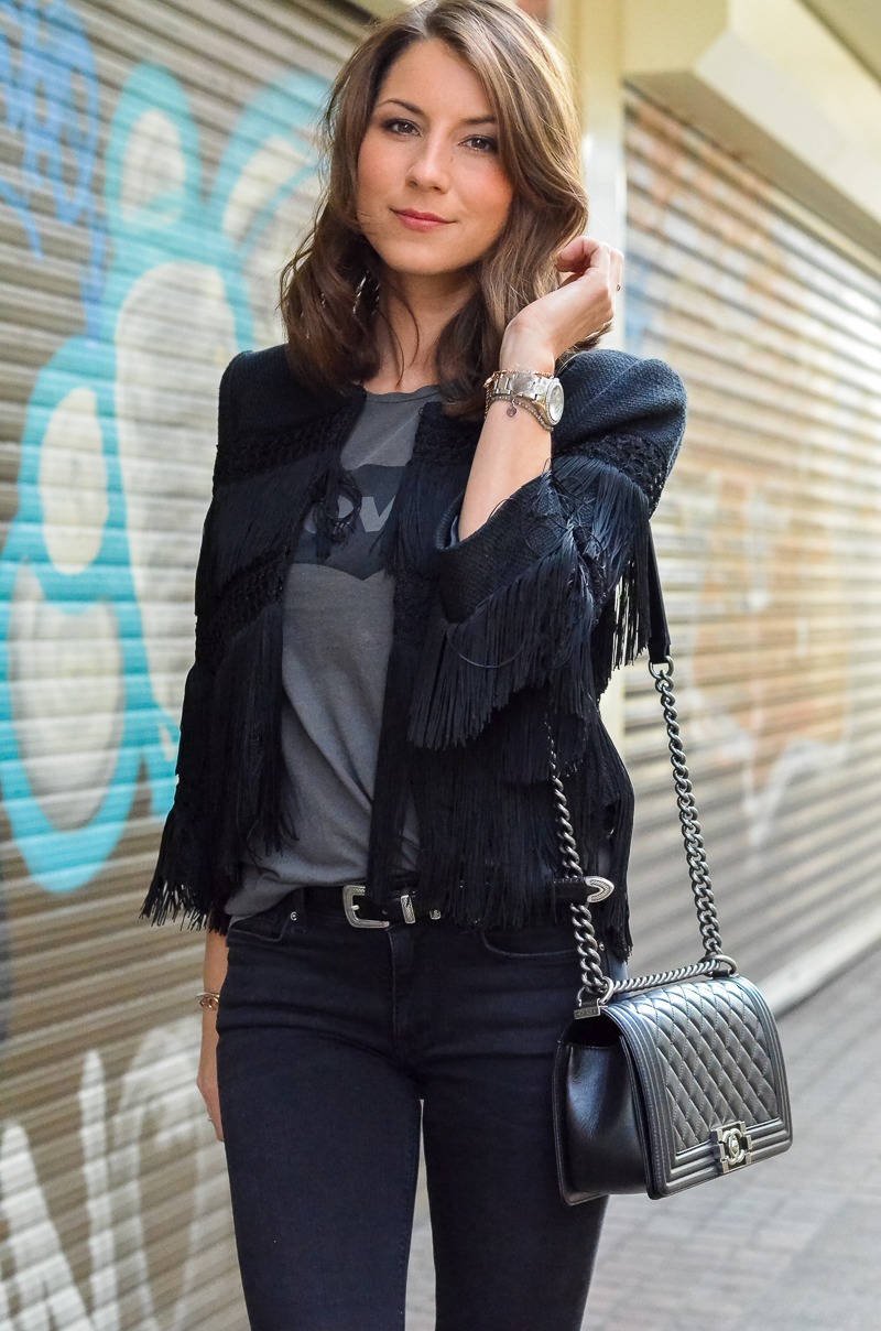 Outfit schwarze Fransenjacke, Levi's T-Shirt, Jeans Schlaghose von Zara und Chanel Boy Bag